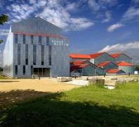 Außenansicht des RömerMuseums im Archäologischen Parks in Xanten. Der Bau ist einer römischen Basilika Thermarum nachenpfunden. Charakteristisch, der trotzdem moderne Museumsarchitektur, ist die graue Fassade und die roten Dächer.